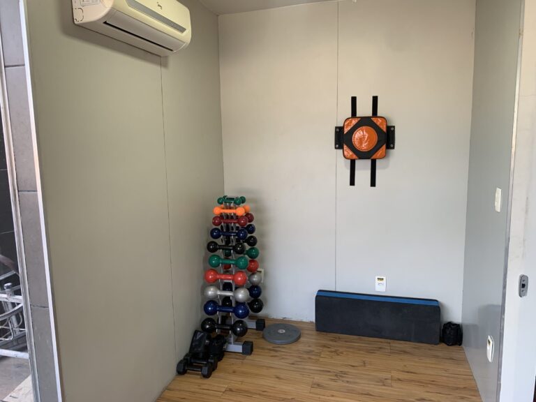 Suporte com halteres e estação de treino funcional na parede