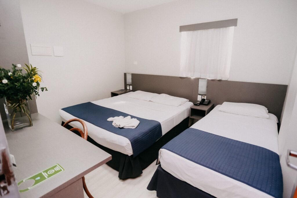Apartamento Standard com cama de casal, cama de solteiro, escrivaninha e arranjo de flores