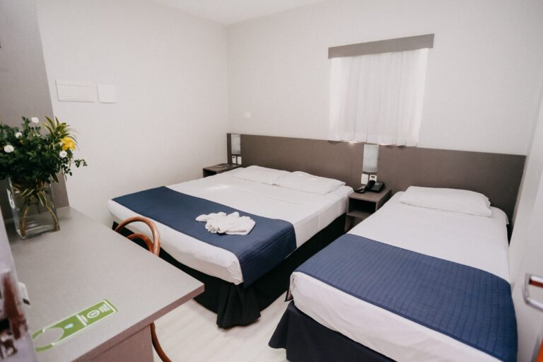 Apartamento Standard com cama de casal, cama de solteiro, escrivaninha e arranjo de flores